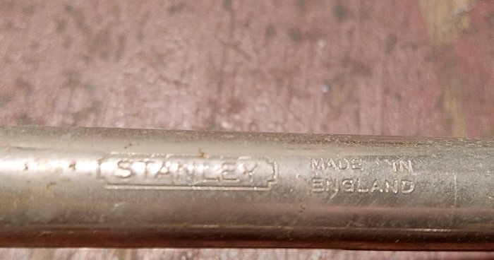 Närbild av en handverktygsskaft med "STANLEY MADE IN ENGLAND" graverat på metallen.