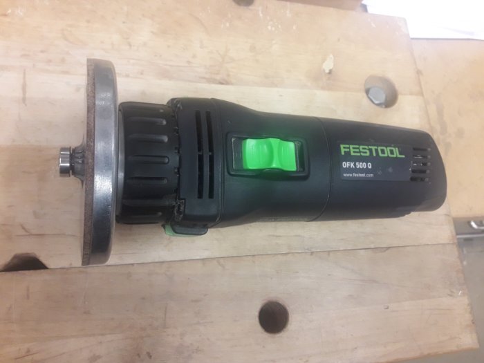 Festool OFK 500-kantfräs med märkta radiefräsar för identifiering, placerad på träbänk.