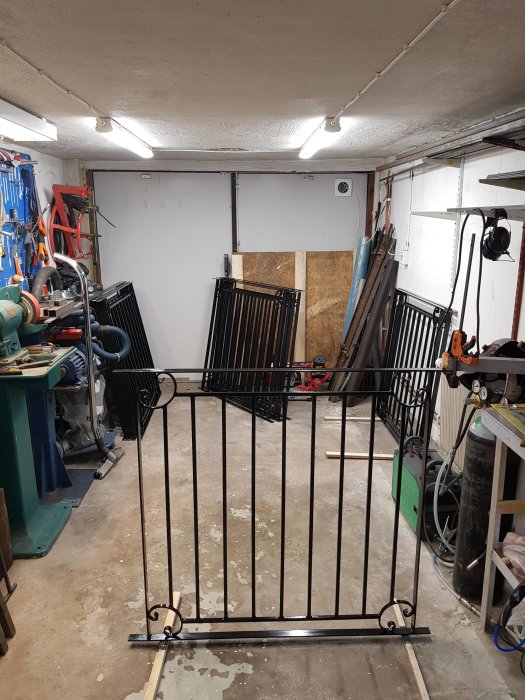 Nyinstallerat smidesstaket i ett garage med verktyg och maskiner på väggarna.