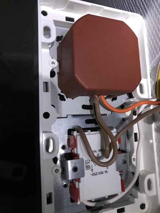 Öppen väggdimmer med kablar anslutna till anslutningsterminaler, korrekt installation verifierad.