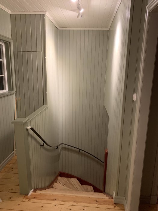 Nyinstallade lister längs väggarna i ett nymålat, ljust trapphus.