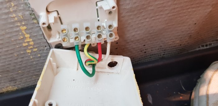 Elanslutningsdosa med synliga ledningar och kopplingar, potentiellt felaktigt ansluten jordning.