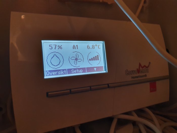 Hygrometer som visar 57% luftfuktighet och 6.8°C installerad i ett hem.