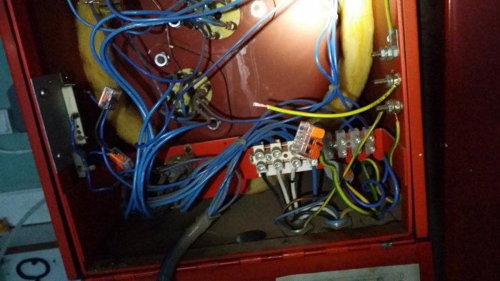 Elcentral med öppen dörr som visar kablar och säkringsanordningar, ingen ström påslagen.