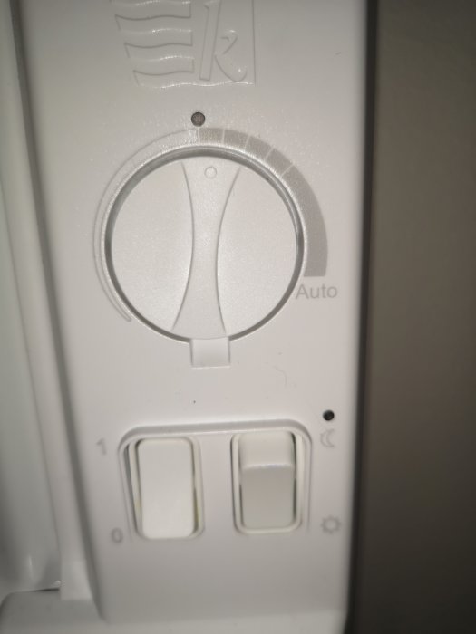 Närbild av en Gnosjö elradiator med manuellt inställningsreglage och strömbrytare.