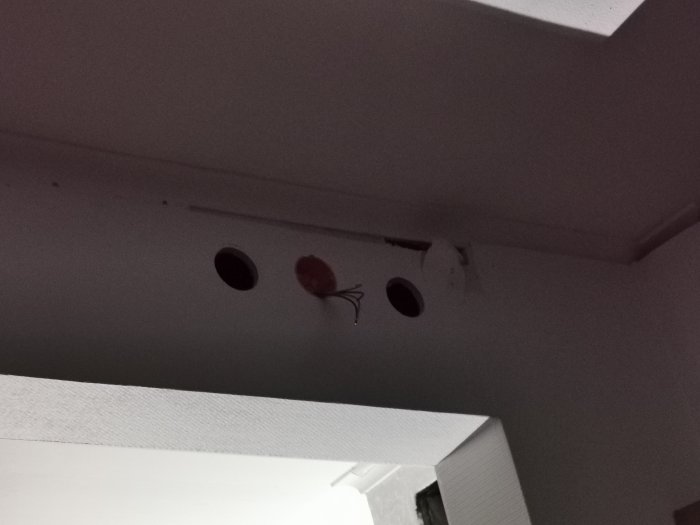 Flertal hål i taket orsakade av elektriker som letar efter väggdosor.