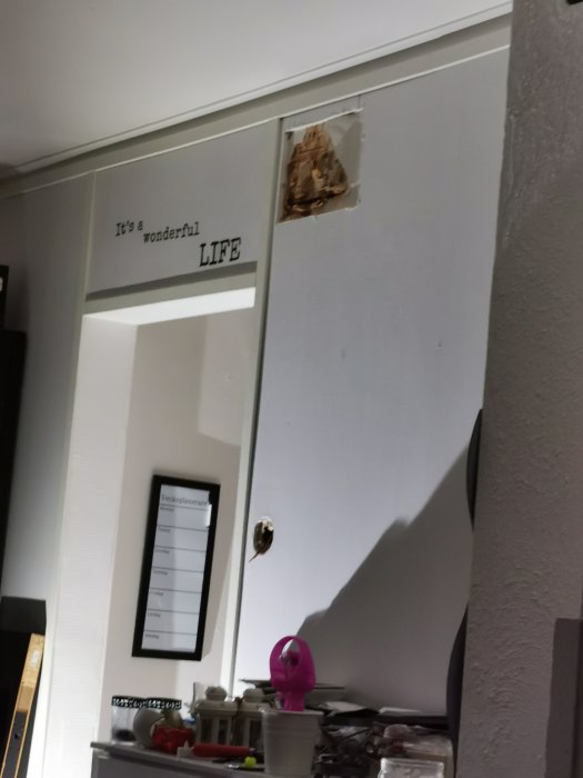 Stort hål i gipsskiva på vägg under renoveringsarbete med synlig kabel och spår av sökning.
