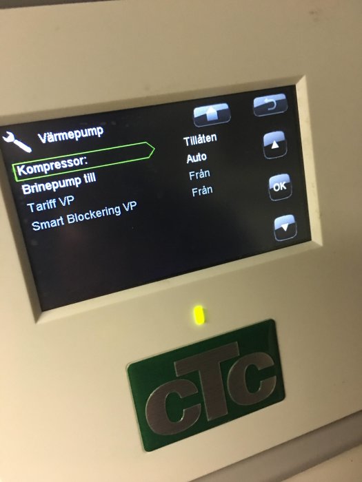 Display på en värmepumpsstyrning som visar kompressor i drift och andra inställningar.