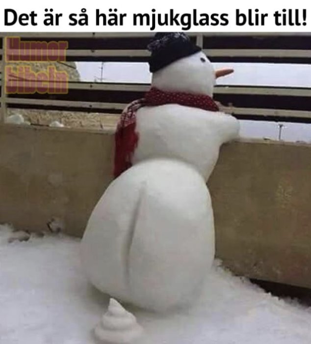 Snögubbe formad som en mjukglass med hatt och halsduk utomhus.