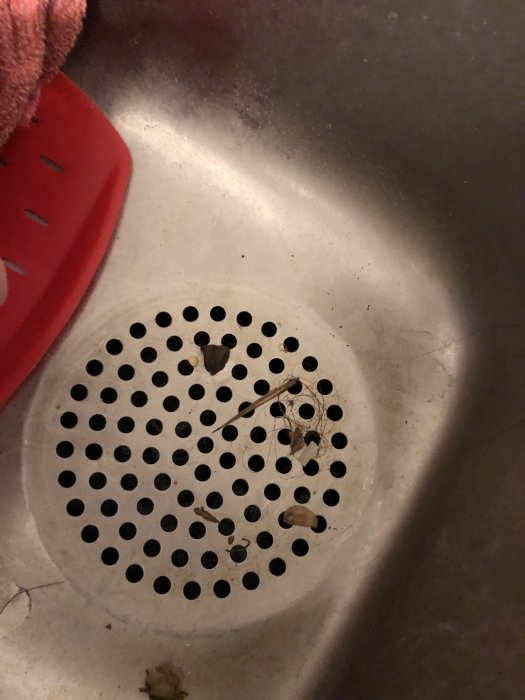Rostfri diskho med ett avtaget 65mm rör, synlig avloppsöppning och spillrester.