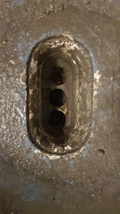 Golvbrunn med synliga blockeringar och uppbyggd smuts, indikerande avloppsstopp.