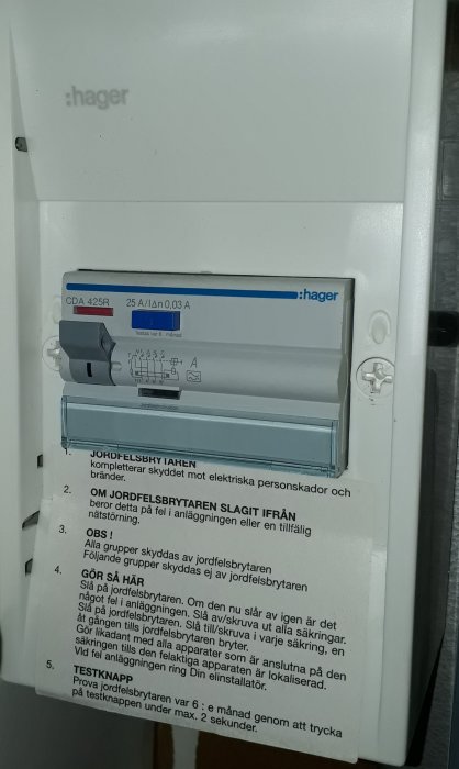 Jordslutningsbrytare i öppet elskåp med etiketter och instruktioner för användning.