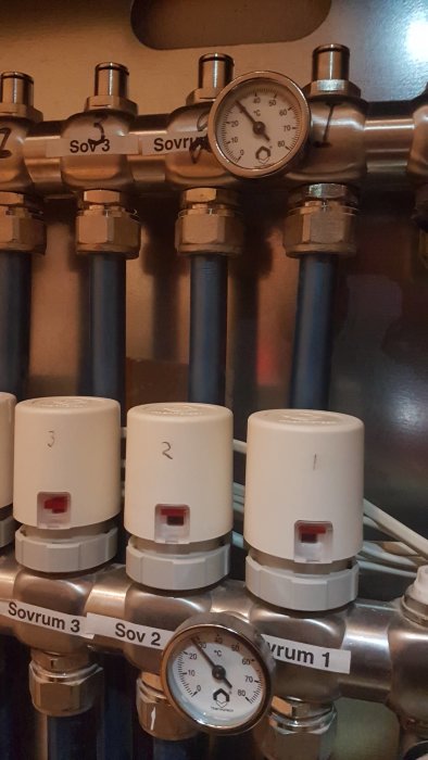 Värmesystems rör med påmonterade Termotech IC R6 ställdon och två temperaturmätare.