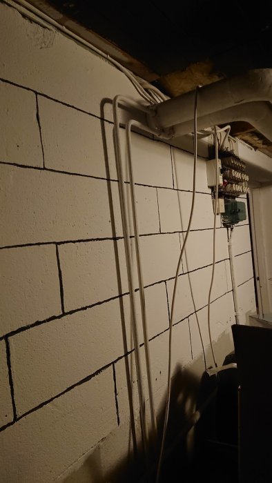 Elcentral med inkommande kabel i vp-rör längs vit vägg med plan för omläggning.