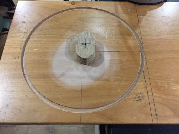 Träskiva med utfräst cirkel och centrumstycke, markerade mått för fortsatt bearbetning.