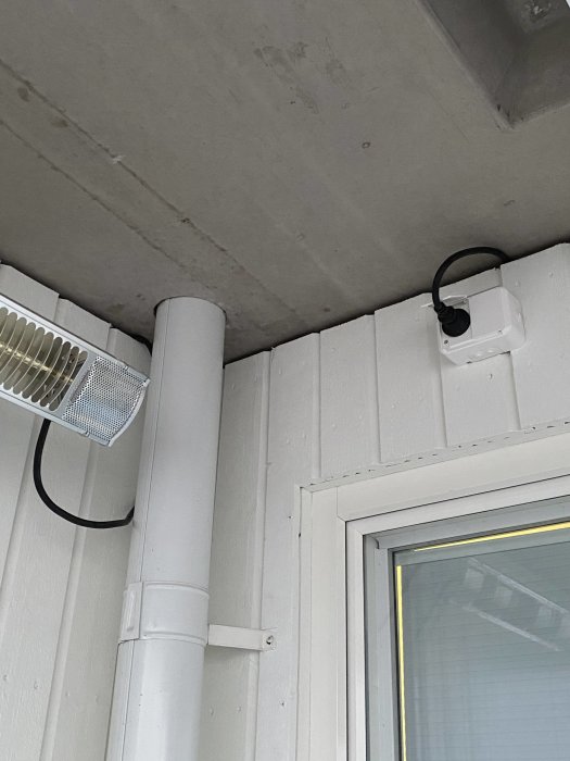 Nyinstallerad kamera med ordentligt monte ledningar längs en vit trävägg och tak.