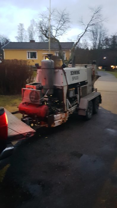 Betongbil parkerad vid ett bostadsområde i skymningen, förberedd för byggprojekt.