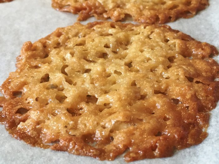 Nygräddade knäckeflarn på bakplåtspapper med gyllenbrun färg och hålstruktur.