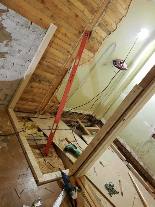 Renoveringsarbete med nya väggstommar och verktyg i ett badrum under omkonstruktion.