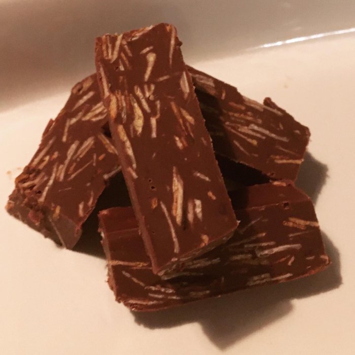 Hemmagjord wienernougat med hackade mandlar på en vit tallrik.