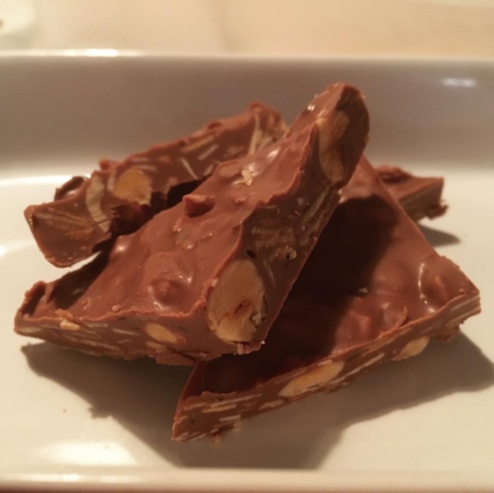 Hembakad wienernougat med hela nötter på en vit tallrik.