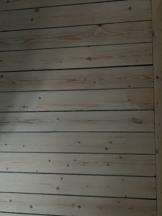 Grangolv med ojämn gråpigmentering och synliga obehandlade träpartier och ådringar.