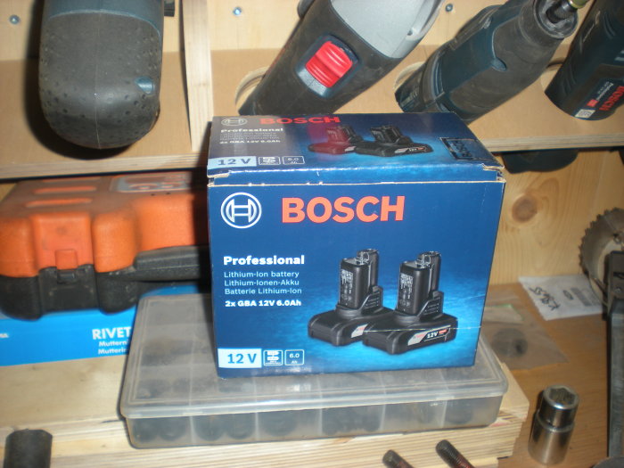 Nyinköpta Bosch 12V 6.0Ah batterier och verktyg på en arbetsbänk.