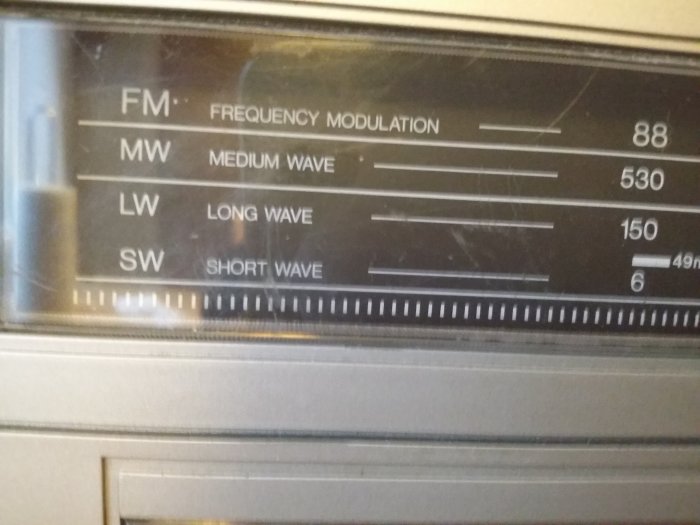 Närbild på en radiofrekvensskala med FM, MW (Medium Wave), LW (Long Wave) och SW (Short Wave).