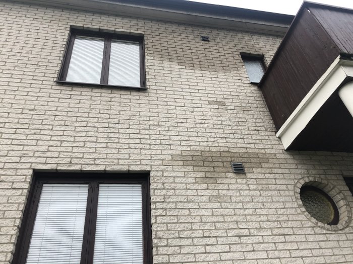 Fasad med vattenfläckar under fönster och vid ventilationsutblås.