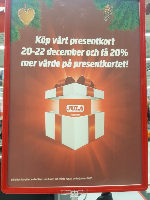 Reklamskylt för presentkort med erbjudande om 20% extra värde vid köp under specificerade decemberdatum.