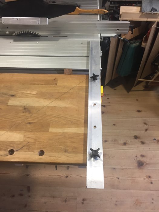 Anpassat justerbord i verkstad med ett hyllplan i ek och en Metabo justersåg med en aluminiumvinkellist.