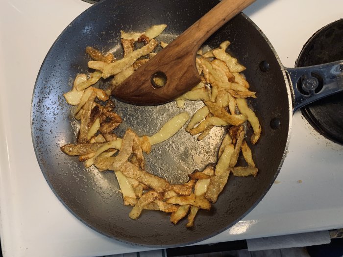 Stekpanna av stål med inbrända potatisskal och salt används för att bygga patina.