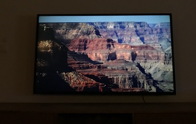 En 55 tum stor TV monterad på en vägg visar en bild av Grand Canyon.