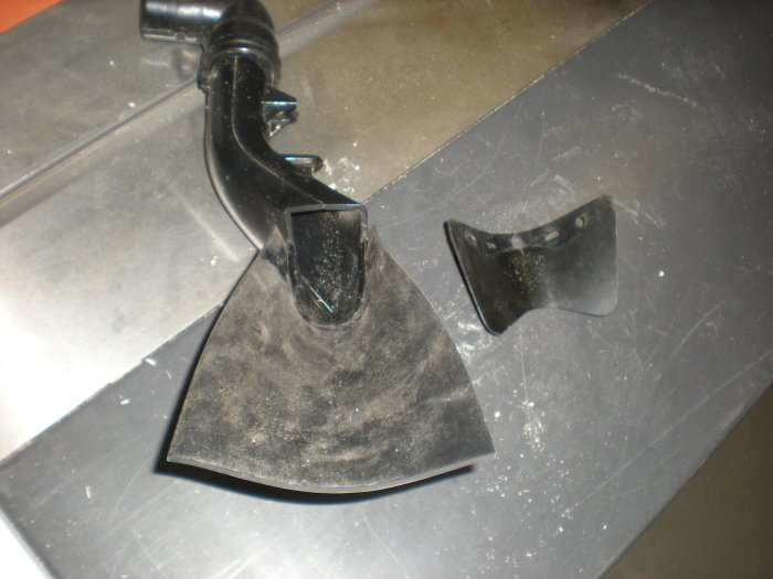 Gummifläpp och modifiering för spånutsug på såg, vid ett sågbord med spånröret till höger.