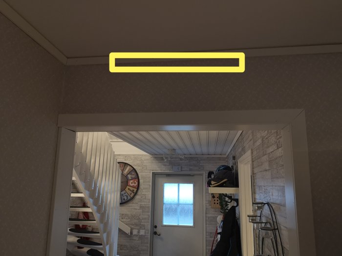 Vägg ovanför dörröppning i hemmiljö där ett ventilationsgaller kan placeras för värmedistribution.
