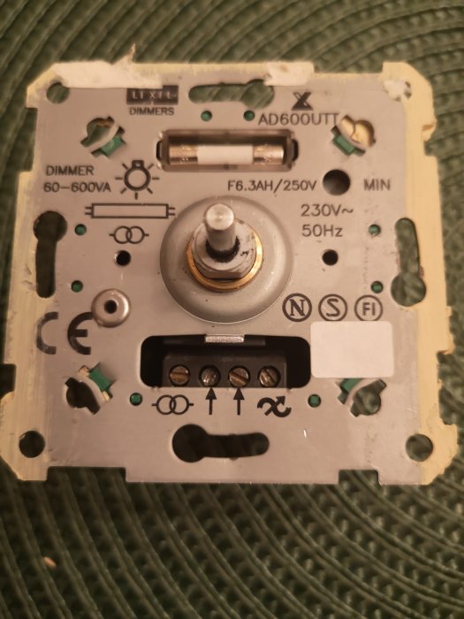 En trasig LEXEL AD600UT dimmer för halogenspottar med synlig mekanisk skada på tryckknappen.