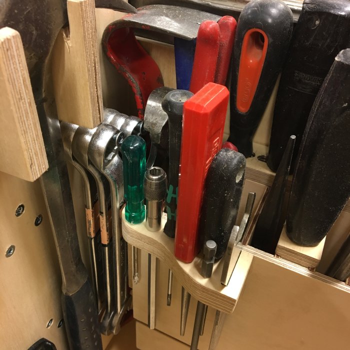 Välordnad verktygshållare med diverse handverktyg inklusive mejslar och filer.