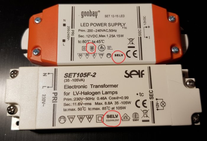Två elektroniska transformatorer för lågvoltshalogenlampor, en märkt med SELV och en med "SELV EQUIVALENT".
