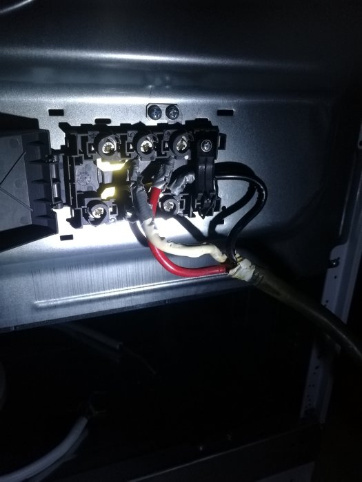 Elektriska anslutningar bakom en fungerande spis som nyligen installerats.