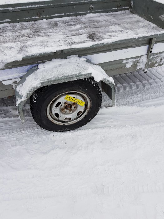 Vinterdäck på släpvagn fastnat i snö med tydliga spår efter försök att släppa bromsen.