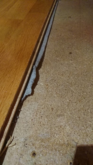 Trägolv möter betongunderlag där en vägg tidigare har varit belägen.