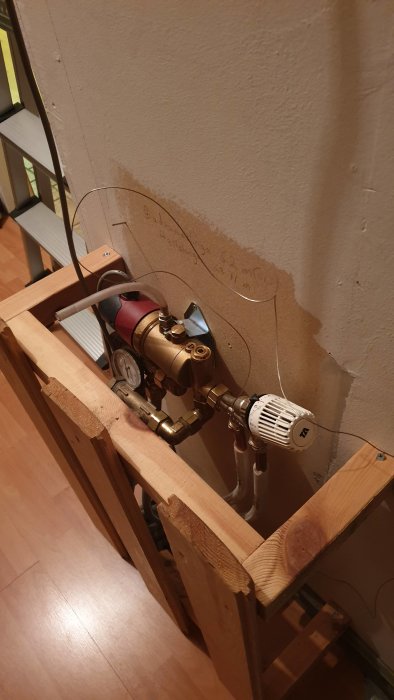 Installationsarbete av värmesystem med cirkulationspump och kopparledningar på en träställning.