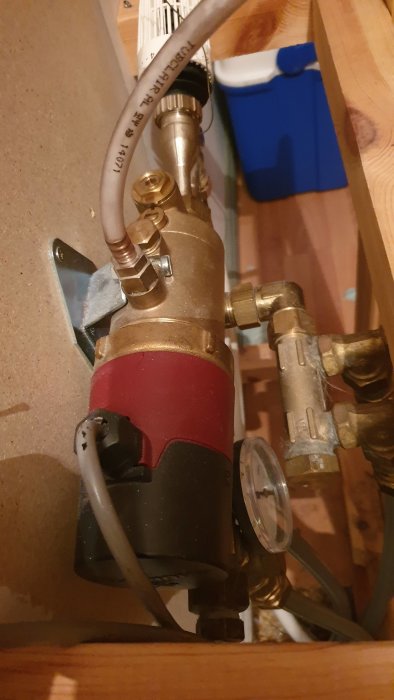 VVS-installation med cirkulationspump och rörkopplingar i ett hem.