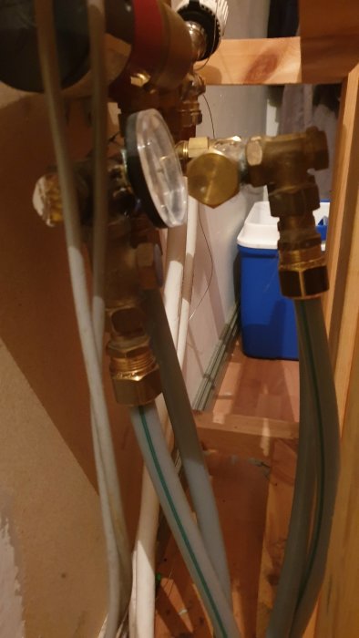Mässingsventiler och genomskinliga rör i ett pågående VVS-installationsprojekt.