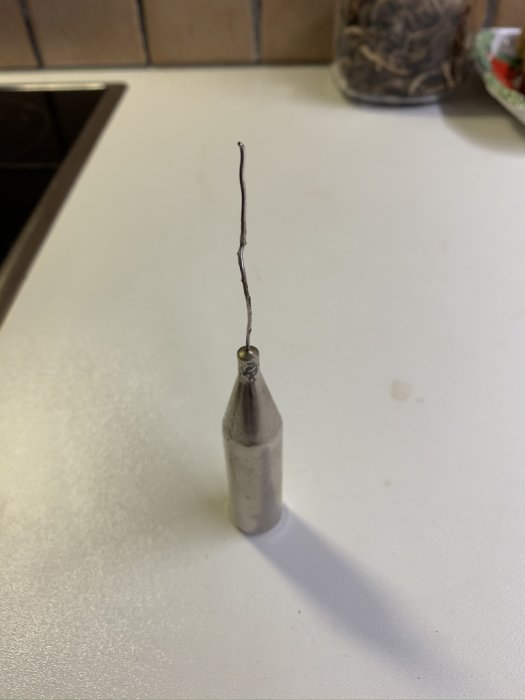Skadad termostat eller sensor till golvvärmepump med exponerad tråd.