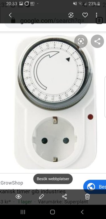 Mekanisk timer med urtavla och eluttag, monterad på vit bakgrund.