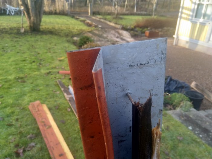 Vikt metallplåt vid fotplåtens utstick i en trädgård, visar detalj för falsat tak.