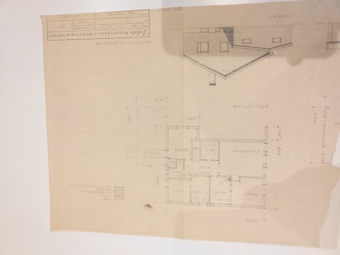 Arkitektritning av ett hus med både planvy och fasad, på ett skrynkligt papper.