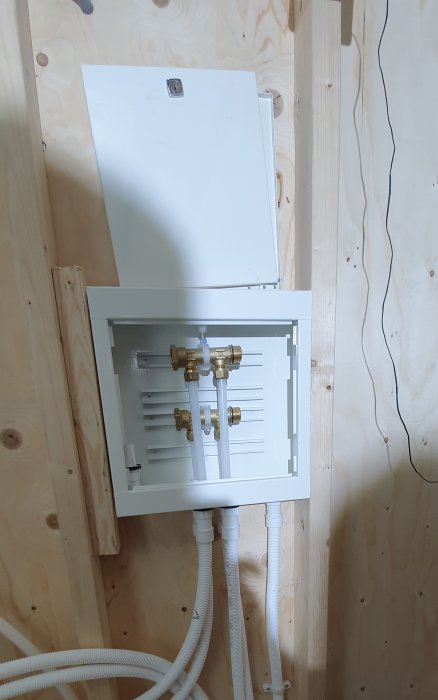 Installationsvy av Uponor vattenfördelarskåp med R15-avstick och rör i ett pågående badrumsprojekt.