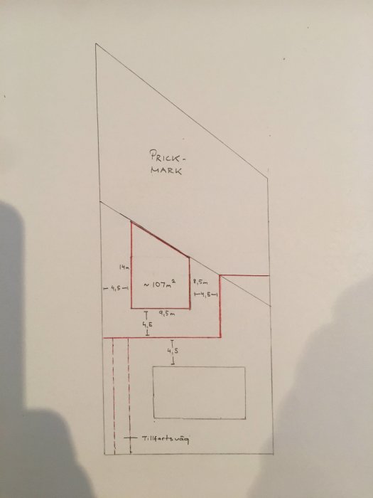 Handritad skiss av tomtgräns och potentiellt byggprojekt med måttangivelser och 107 kvm byggyta.